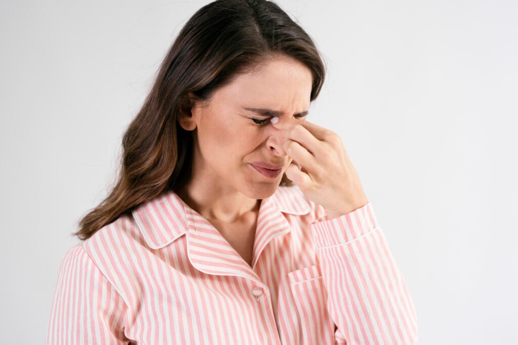 Woman with sinus pain pressing the bridge of her nose